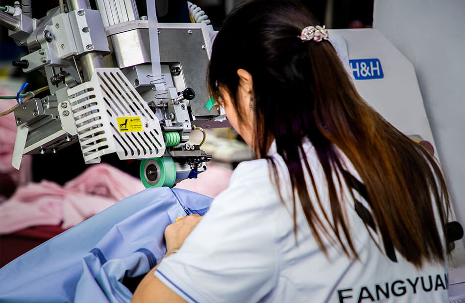 An skilled woman worker is sewing jackets