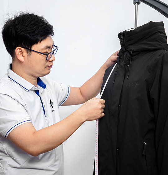 A designer is measuring the sizes of a sample jacket